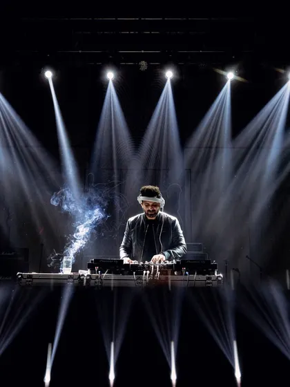 The DJ spinning tracks under dramatic spotlights, keeping the energy high all night long.