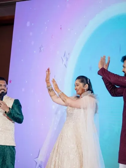 A high-energy moment on stage with the couple, teaching them a fun dance move. My goal is to make them feel comfortable and have a blast.