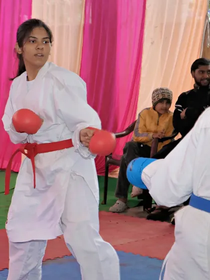 A female student in a sparring stance during a competition. Her focus and readiness show the confidence we build.