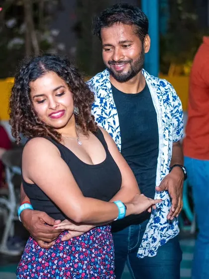 A close and happy dance. The floral skirt and black top are a great combo for a night of dancing.