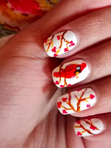 An example of hand-painted nail art. This charming "winter berries" design with a cardinal bird shows the level of detail and creativity we explore in my nail art workshops.