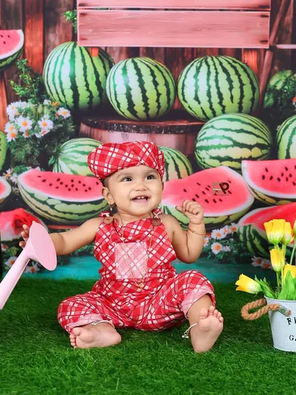 Another delightful shot from the watermelon patch, with the baby smiling and ready to play. The pink watering can and potted flowers add to the garden feel.