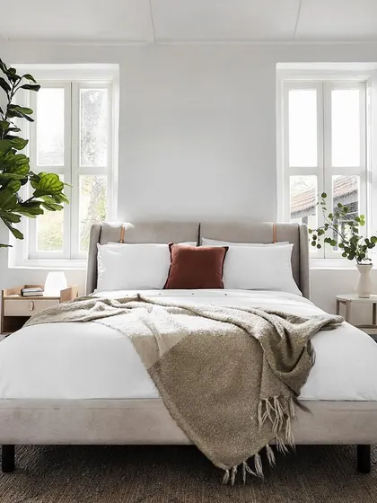 The Crème bed in a bright, sunlit room, embodying comfort and style. The light-colored upholstery and minimalist design make it a perfect centerpiece for a serene and modern bedroom.