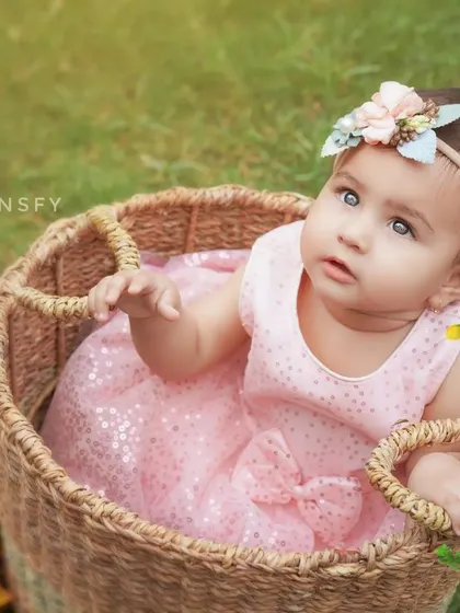 A sweet portrait of a baby girl in a wicker basket, surrounded by nature. Outdoor sessions are perfect for capturing beautiful, light-filled images.