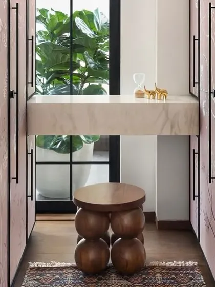 A detail of the vanity area within the West Coast Residence walk-in closet. The space is designed to be both practical and beautiful, with a marble countertop and a view to the outdoors.