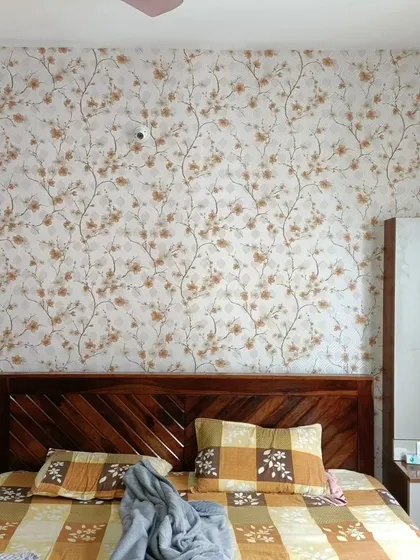 A bedroom accent wall with a lovely cherry blossom wallpaper. The warm, neutral colors create a peaceful and inviting space.