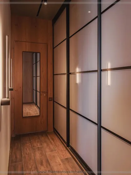 For a look of ultimate minimalist sophistication, we designed this wardrobe with 10-foot-tall profile shutters in sleek, back-painted glass. The seamless, reflective surface makes the space feel larger and more modern.
