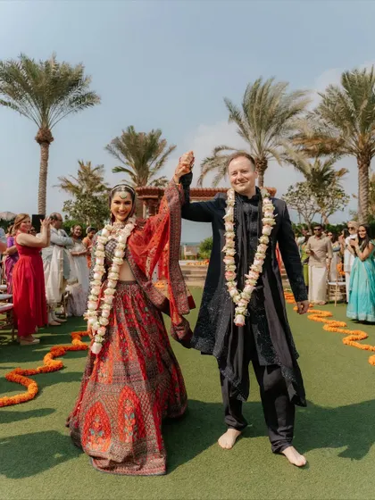 The "just married" walk. The couple's triumphant hand-in-hand walk down the aisle after the ceremony, surrounded by cheering guests and a beautiful outdoor setting.