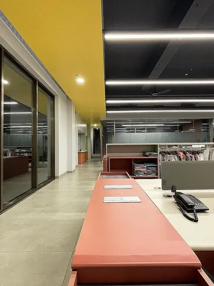 A similar view of the VEE CEE EXPORTS office, showing the long corridor and glass partitions that maintain a sense of openness.