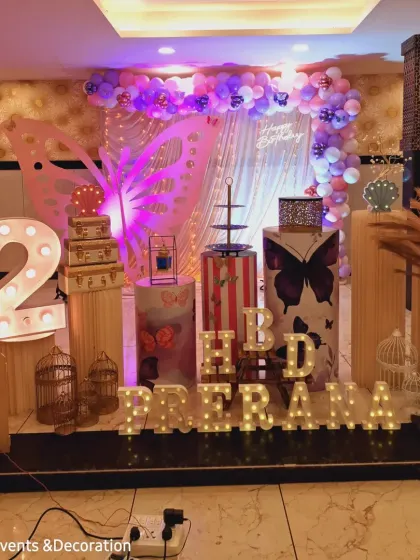 This angle shows the setup process, with the lighting and props being arranged for the butterfly-themed party. It's a peek into the hard work that goes into each event.