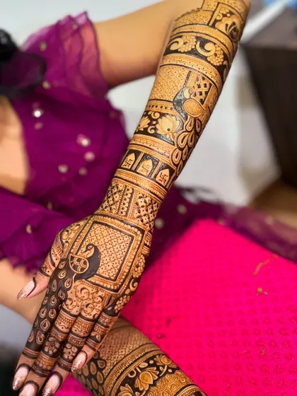A full-arm bridal mehendi showcasing intricate peacock and floral patterns. This was a collaborative effort, showing the detailed work my team and I can produce.