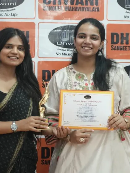 A teacher presents an award to her student.