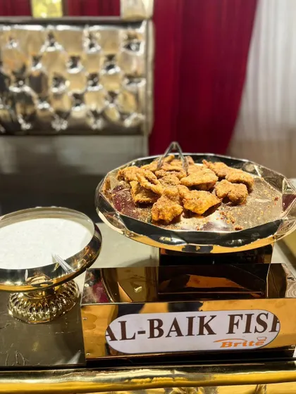 Al-Baik style fried fish, served with a creamy dipping sauce, offering a taste of Middle Eastern flavor.