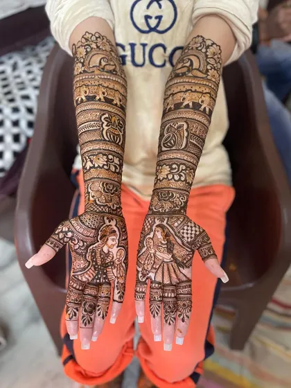 The complete view of this intricate bridal mehndi. The design flows seamlessly from the fingertips to the elbows, telling a story with every element.