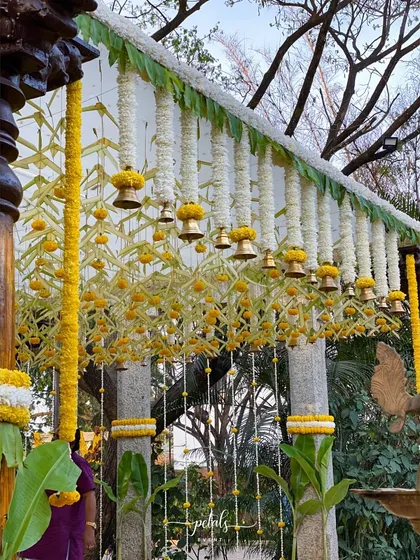 The interplay of light and shadow on the decorated pillars and hanging bells creates a magical ambiance. This is how I use natural elements and traditional decor to craft a truly special wedding experience.