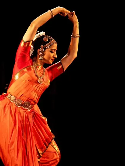 A dynamic shot of Ramya Suresh in motion, her costume flowing with her as she moves across the stage.