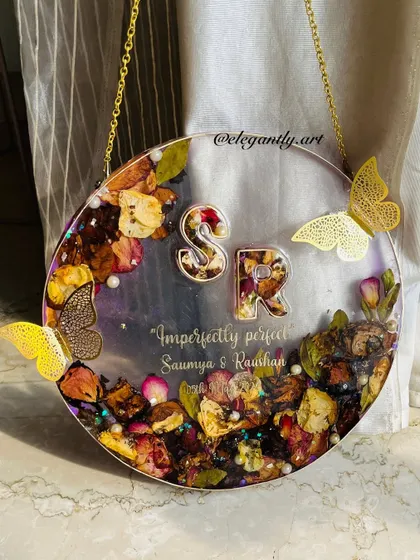 Flower preservation done in a unique way. This transparent hanging frame gives the illusion of flowers floating in glass, creating a truly elegant and modern keepsake.