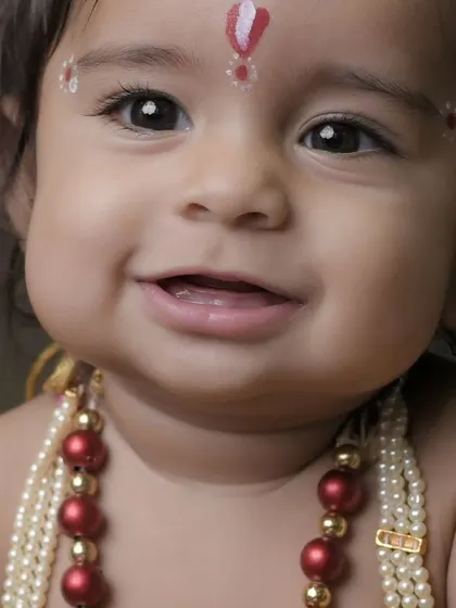 An intimate close up capturing the innocent and divine smile of this little one. We focus on the fine details, from the tilak to the beaded necklaces, to make every shot perfect.