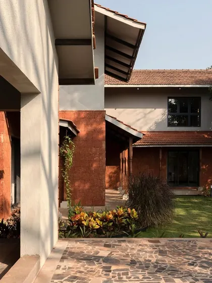 The courtyard at Maison Rouge, showing the beautiful contrast between the red laterite stone and the green lawn.