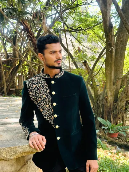 Another angle of the dark green bandhgala, highlighting the intricate embroidery that flows from the shoulder down the sleeve.
