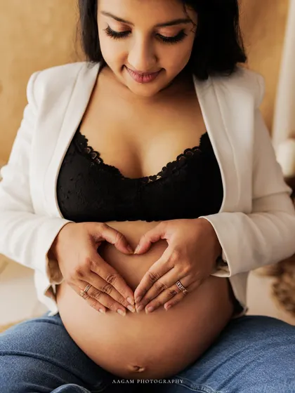 The heart hands, a simple and universal symbol of love for the little life growing inside. A beautiful, modern portrait.