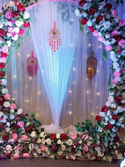 A view of the Bohemian-style floral ring backdrop without the seating. This shows the full structure, including the sheer white drape and fairy lights that create a magical effect.