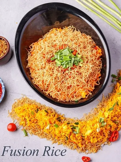 Singapore Fusion Rice is a vibrant and flavorful dish. Spicy fried rice is topped with crispy fried noodles, offering a delightful mix of textures and a tangy taste.