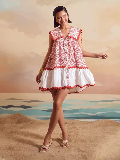 A joyful, smiling shot for Qala Clothing, featuring the Red Schiffli Sailor Dress in a dynamic pose.