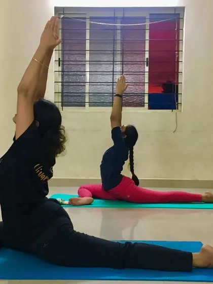 A side view of students in Ekapadasana, highlighting the deep stretch in the hips and back.