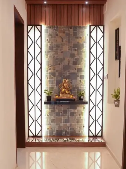 A welcoming entrance unit in the Velachery apartment, with a stone-clad wall, a Ganesha idol, and warm backlighting creating a divine first impression.