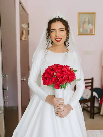 A full-portrait of this elegant bride. Her modest gown, red bouquet, and bright smile create a look of pure, timeless beauty.