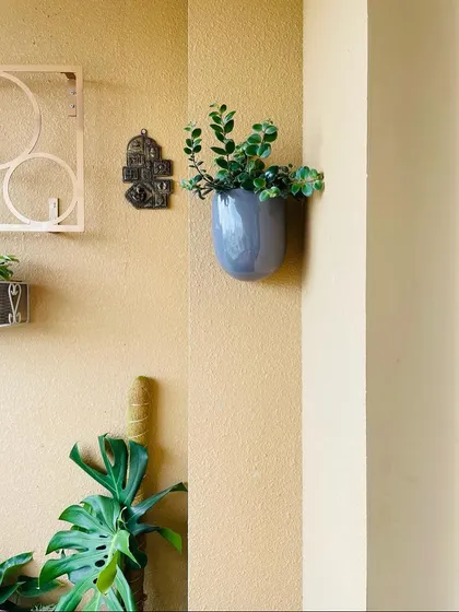 Here you can see how a single wall planter can complement a larger arrangement below. Every detail contributes to turning a collection of pots into a cohesive garden design.