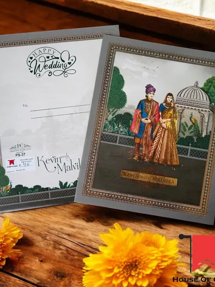 A Raja-Rani theme invitation with a more illustrative, modern feel. The couple is framed by a beautiful palace window, creating a romantic scene.