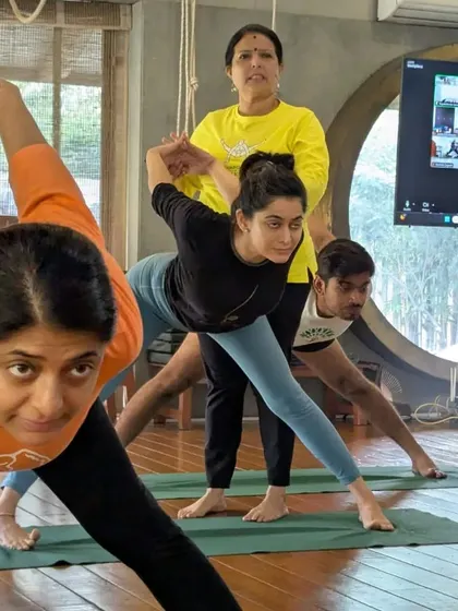 A class in session, with students practicing a standing pose. The energy and focus in the room are a testament to the power of this practice.