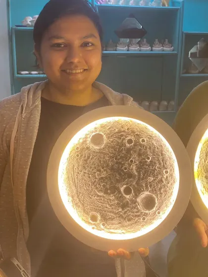 The pride of creation. A participant holds up her large, beautifully textured moon lamp.