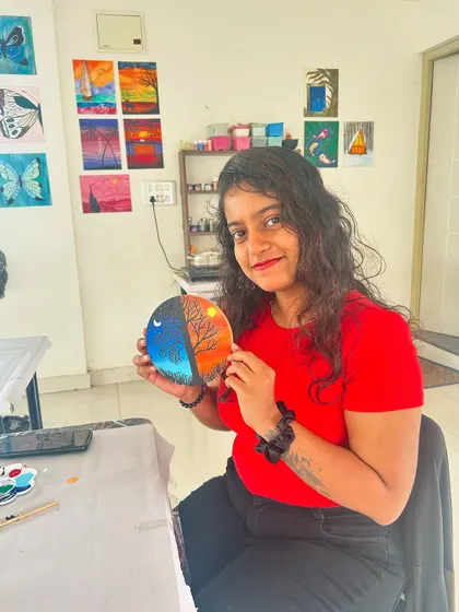 A participant shows off her creative day-and-night circular painting.