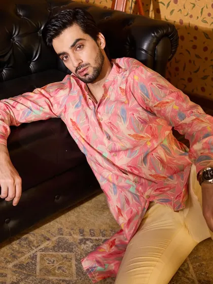 The vibrant, abstract leaf print on this pink kurta adds a touch of artistic flair. Paired with simple cream trousers, it creates a balanced look that is both eye-catching and sophisticated.