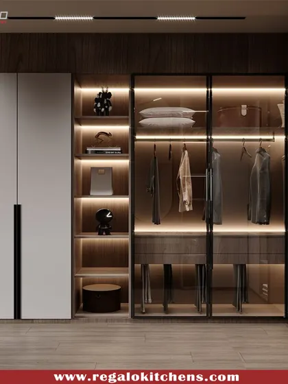 This L-shaped wardrobe combines solid white doors with open, glass-fronted corner shelving. The integrated lighting turns the corner into a beautiful display feature.