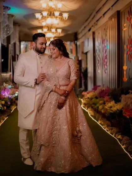 A classic portrait of the couple standing together in a beautifully decorated hallway, looking elegant and in love.
