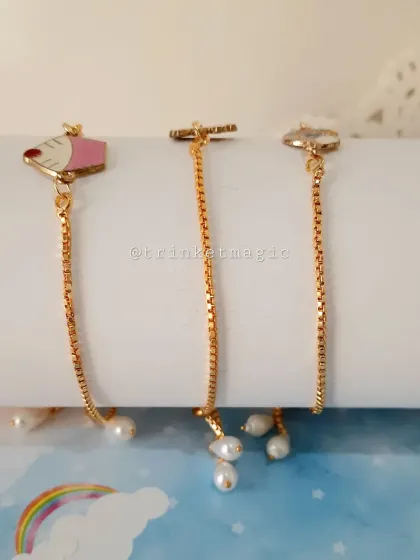 This photo highlights the adjustable ends of the charm bracelets, each adorned with a delicate pearl.
