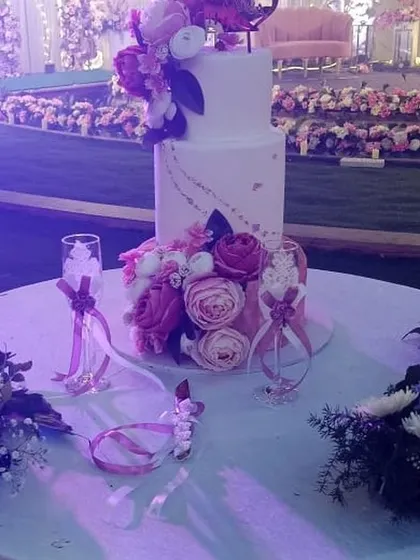 A close-up of a beautiful tiered wedding cake, decorated with fresh flowers.