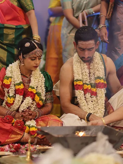 The bride and groom during their wedding ceremony, their hands joined in a ritual, showcasing the bride's henna.