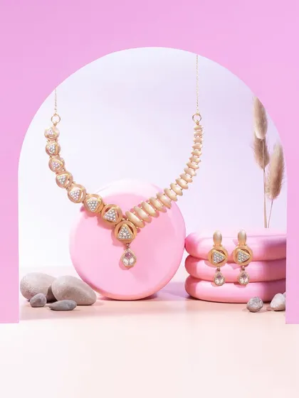 Trends fade, but a statement lasts forever. This matte gold set with triangular diamond motifs and tourmaline drops is for those who stand out effortlessly.