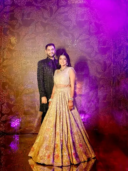 The couple posing at their private nightclub-themed Sangeet. We designed the space with alcoves and intimate seating clusters to create an immersive and exclusive party experience.