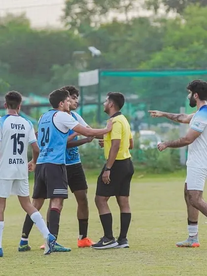 Tensions can run high during a match, but sportsmanship is always key. Players and referees in discussion.