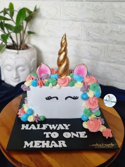 Halfway to one! This unicorn half-cake is a fun way to celebrate a six-month milestone. It features a colorful buttercream mane and a golden horn.