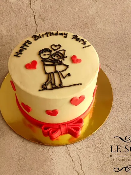 "Just the two of us." This minimalist half-kg Honey Almond cake features a simple line drawing of a couple, a fondant bow, and tiny hearts.