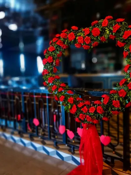 A heart-shaped wreath made of red roses. This classic symbol of love is a beautiful decorative element for an engagement, wedding, or Valentine's Day party.