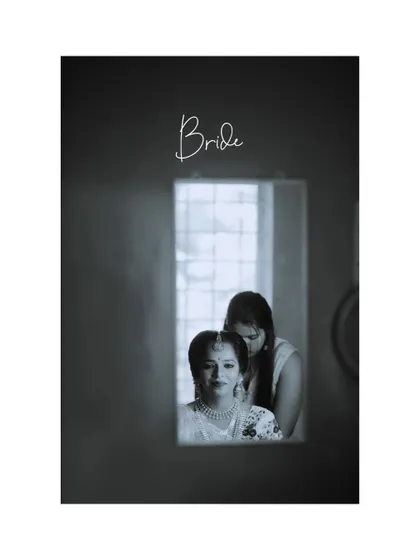 A beautiful black and white portrait of the bride getting ready, captured through a doorway for an intimate, behind-the-scenes feel.