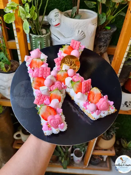 This 'K' monogram tart cake is one of my favorites. It's topped with fresh strawberries, pink chocolates, and marshmallows, making it look as good as it tastes.